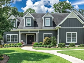 Residential home with green grass under blue sky.
