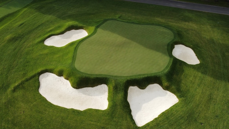 Overhead photo of a golf course with green grass and sandy bunkers