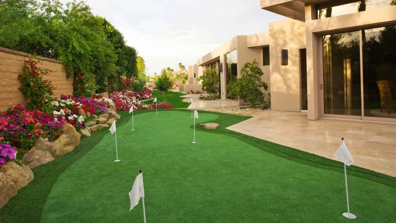 Putting green next to modern house.
