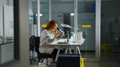 Female barenbrug turf researcher looking through microscope.