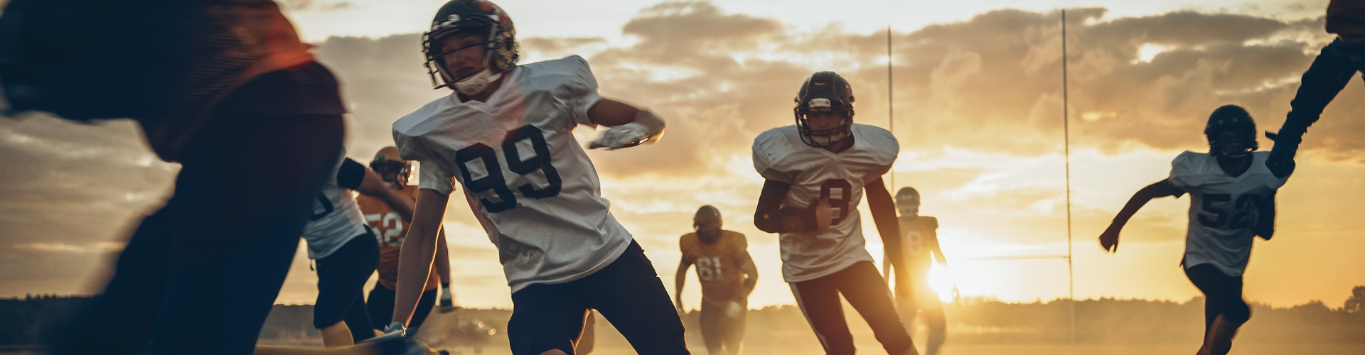 football players on dusty field at sunset
