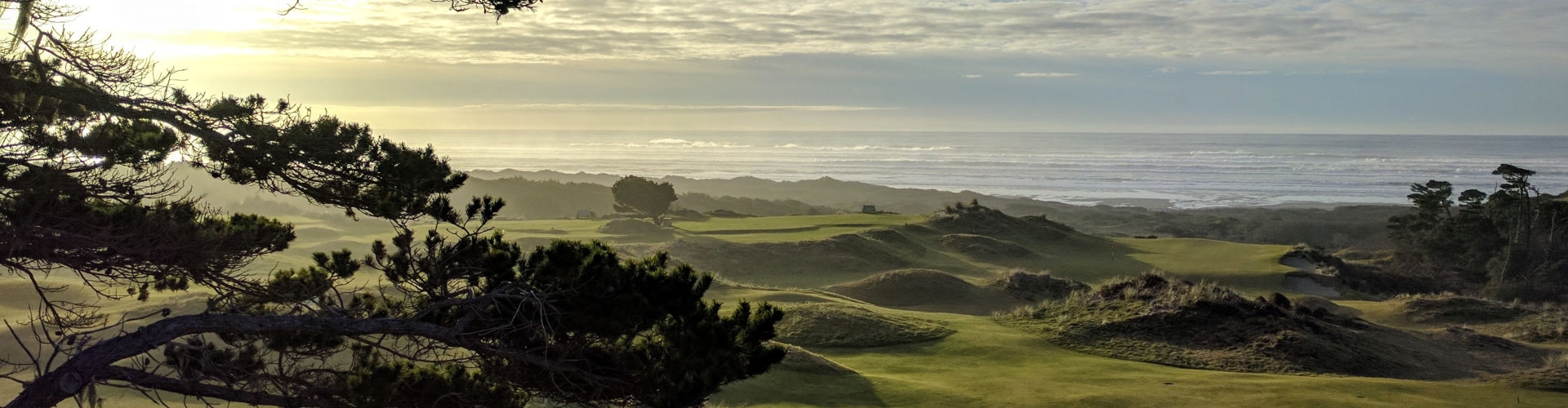Golf course on the coast under a cloudy sky.