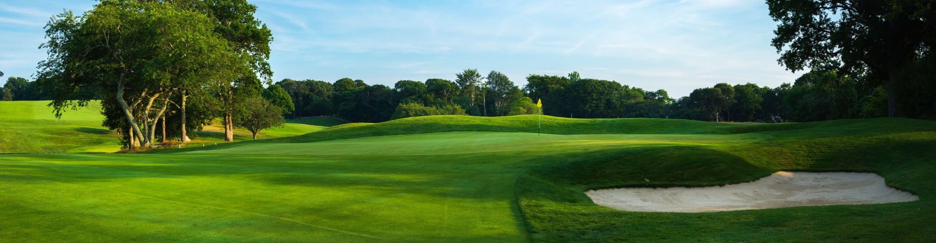 Pristine green fairway and rough on a golf course under a blue sky