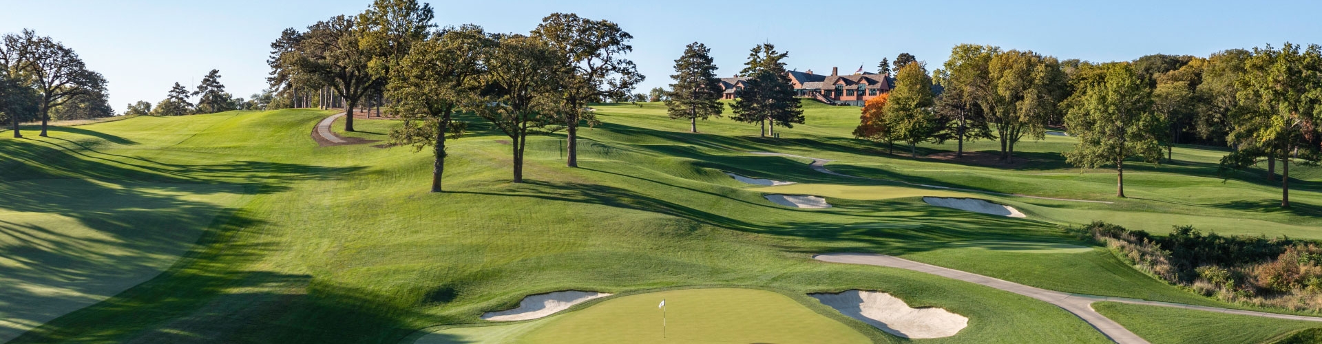 Ariel view of Omaha Country Club's green fairways with RTF bunker surrounds under blue skies.