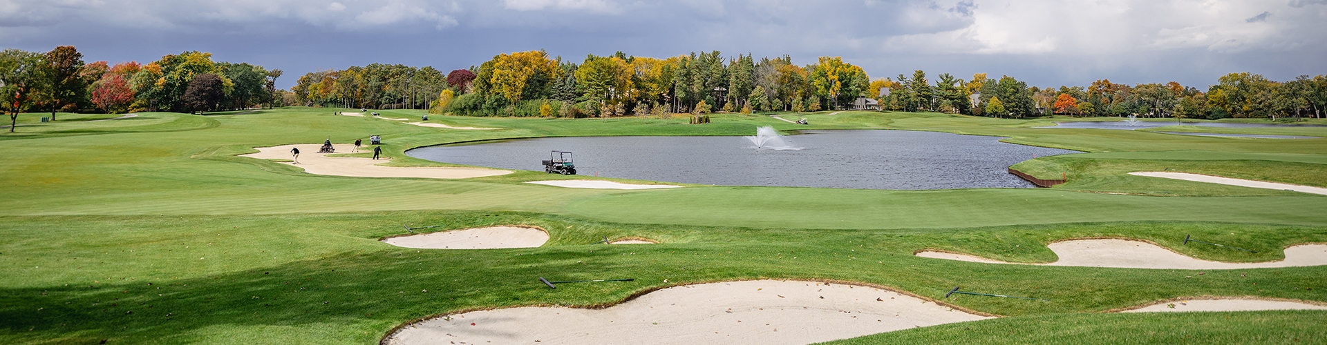 Golf course with water and clouds in sky 