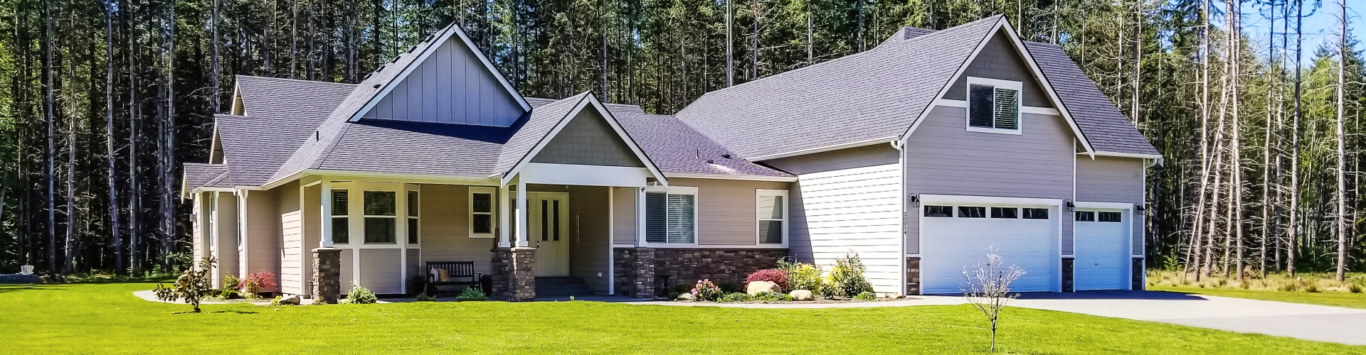 Nice newer home with large flat front yard and trees in the background