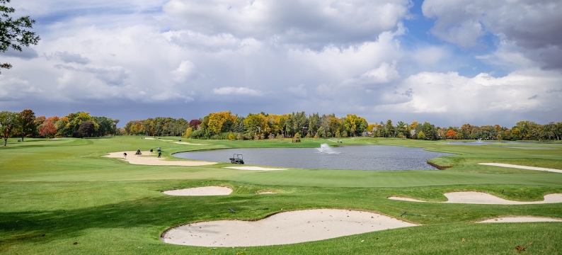 Golf course with water and clouds in sky 