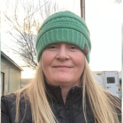 Portrait of woman with long blonde hair and green beanie 